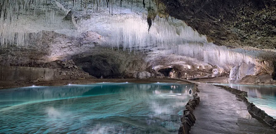 Stalactites and an underground river inside the Grotte de Choranche