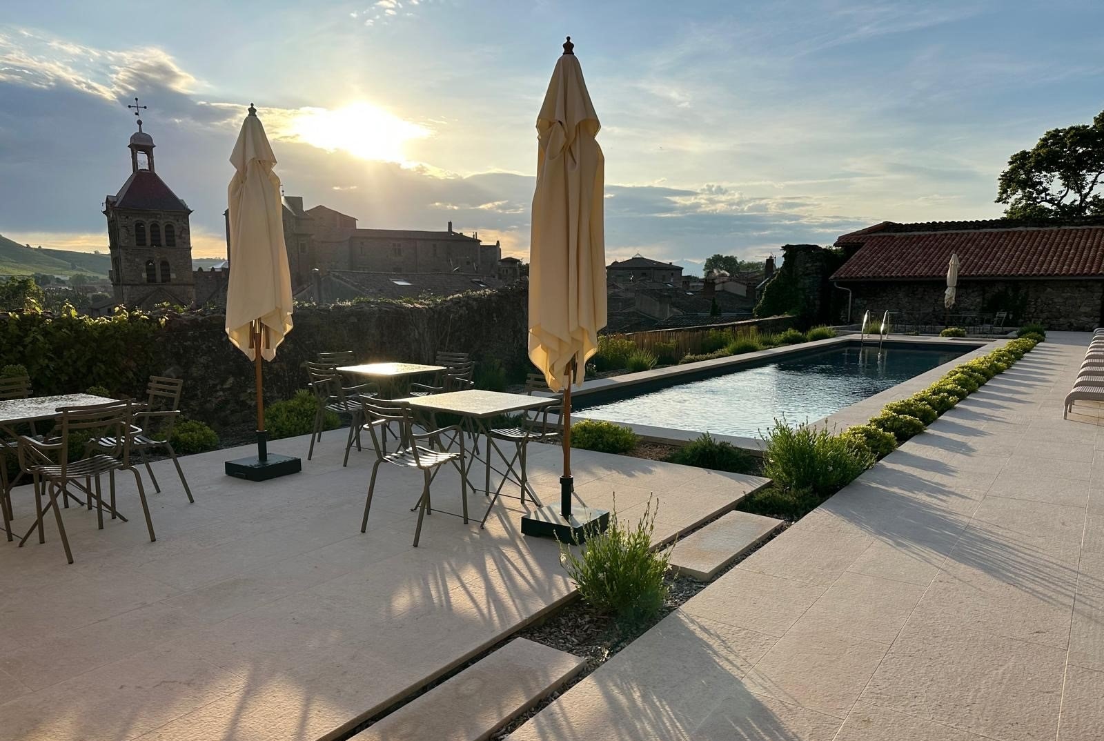Hotel pool terrace at sunset with church and castle views