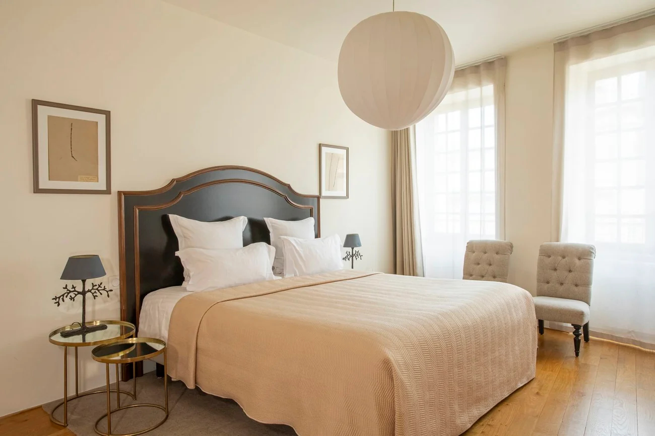 Spacious hotel room with ornate headboard and modern amenities