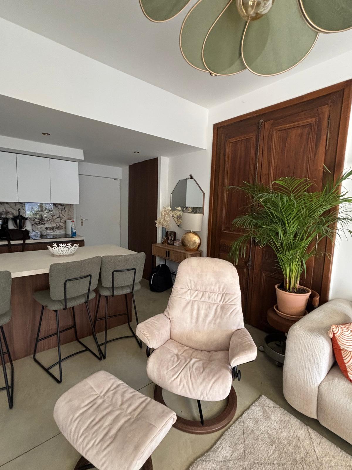 Living room with recliner, kitchen view, and modern decor